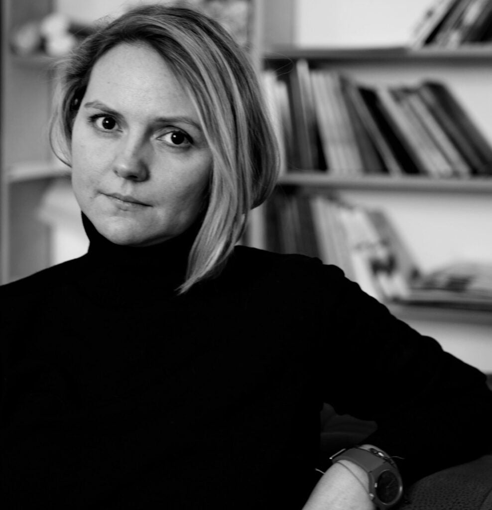 Volha Hapeyeva in black turtleneck with arm reclined.