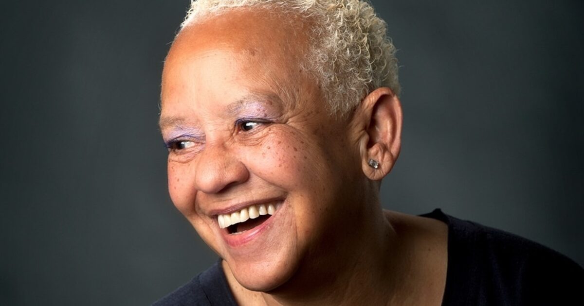 Nikki Giovanni smiling in profile with short white hair.
