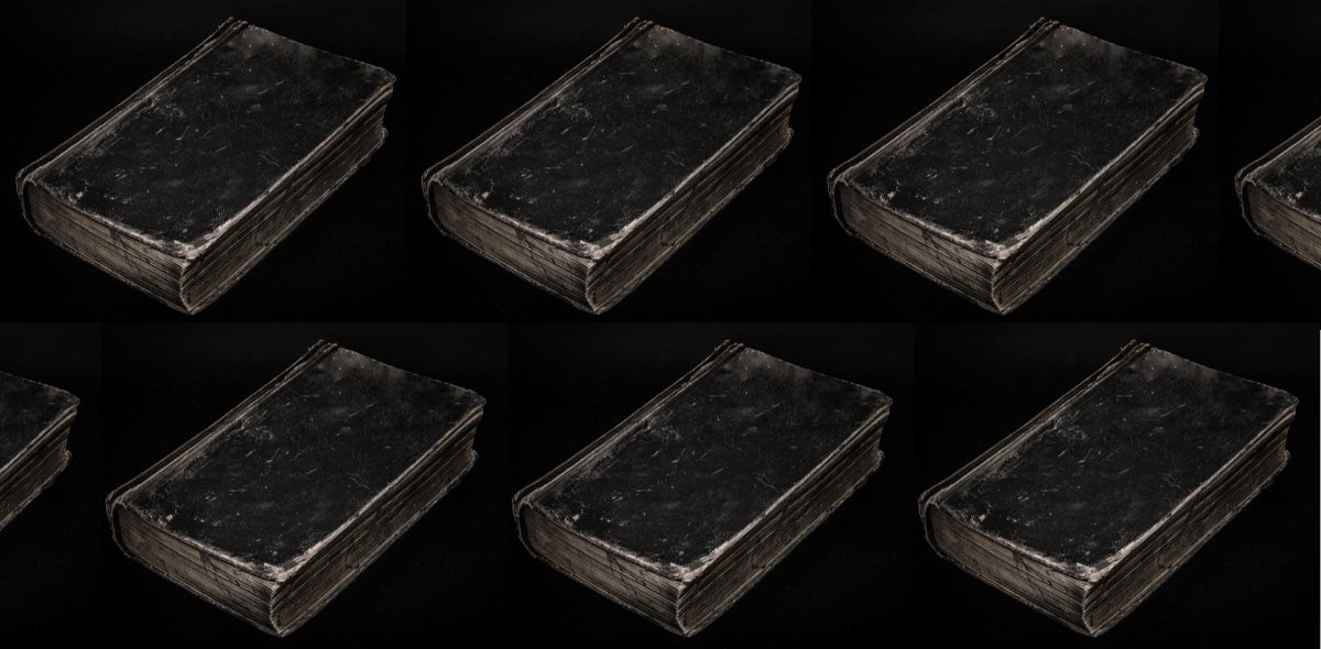 Black background with black and grey covered books.