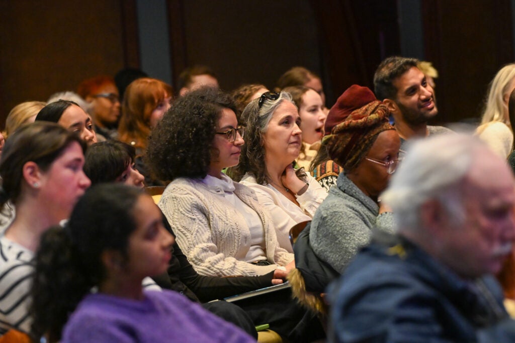 A seated crowd is watching toward the stage on the right (not pictured).